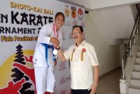 Siswi kelas 9 SMPN I Alok Timur Elisabeth F. Rodriques menerima medali emas dari panitia dalam kejuaraan Kata Perorangan dan Komite Cadet di kelas 54 untuk perlombaan Shotokai  Bali Open pada Juli 2023. Foto Dokumen Pribadi