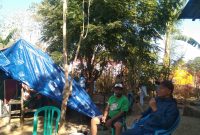 Ketua RT 015/RW 004 Kelurahan Mata Air Kecamatan Reok Marselinus Mbawu (baju hijau) dan Jurnalis Senior Walburgus Abulat berpose dengan latar tenda mandiri.