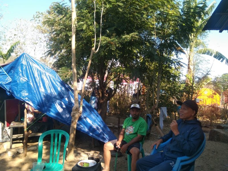 Ketua RT 015/RW 004 Kelurahan Mata Air Kecamatan Reok Marselinus Mbawu (baju hijau) dan Jurnalis Senior Walburgus Abulat berpose dengan latar tenda mandiri.